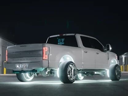White Ford Super Duty dually at night with wheel ring lights and underglow lit up