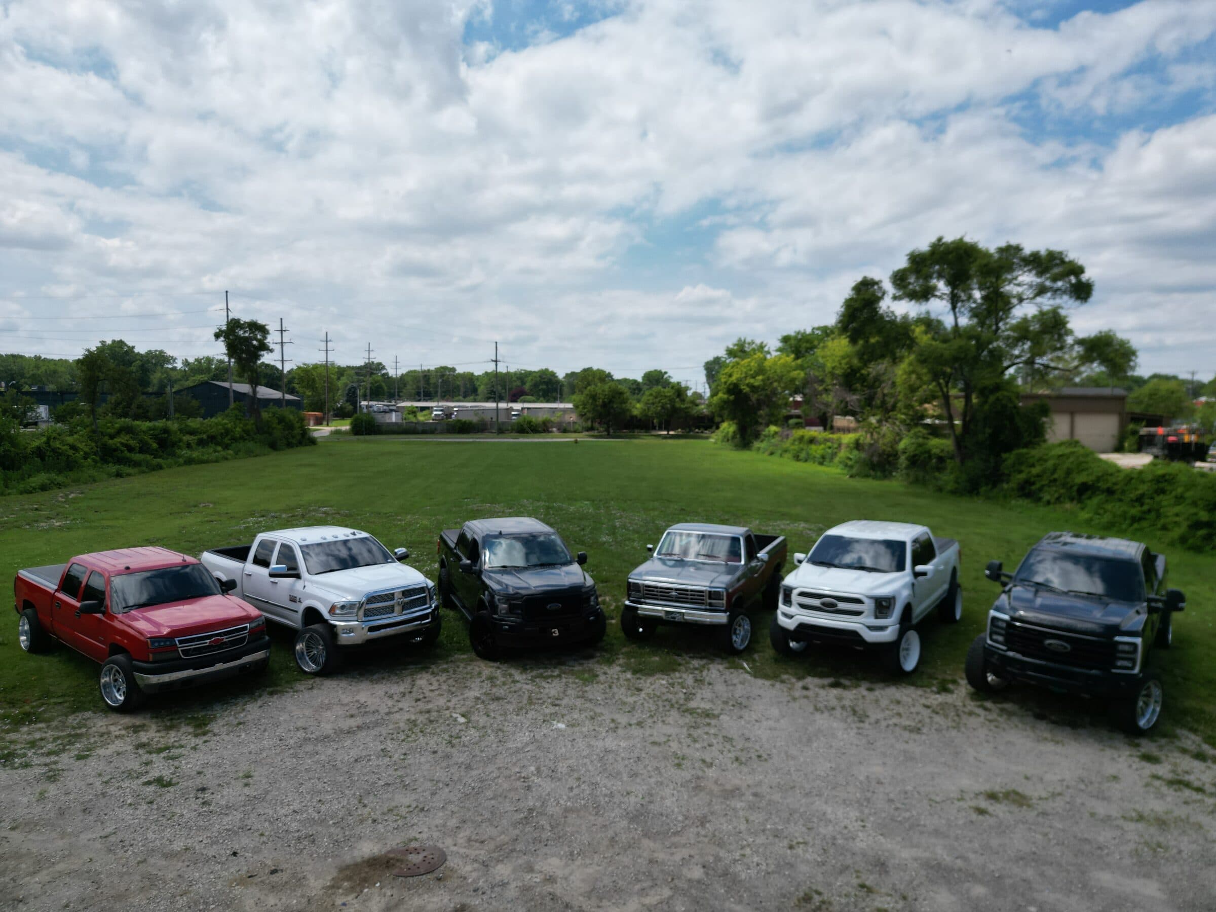 Six trucks belonging to the Street Justice Performance crew lined up in a field